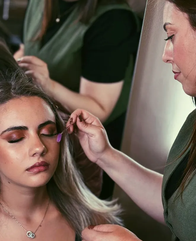 Cliente de cabelo loiro sendo preparada no estúdio